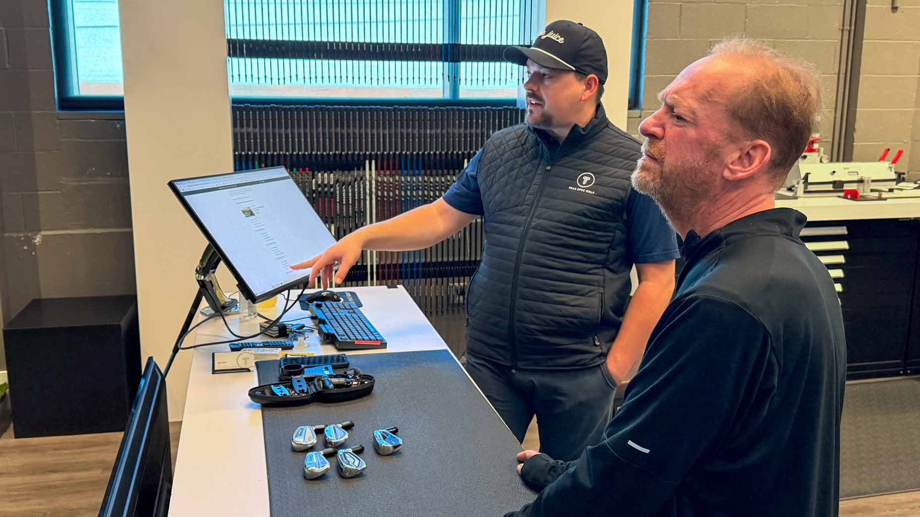 Sam Reef and Brian Gulino go through data during Sam's fitting at True Spec.