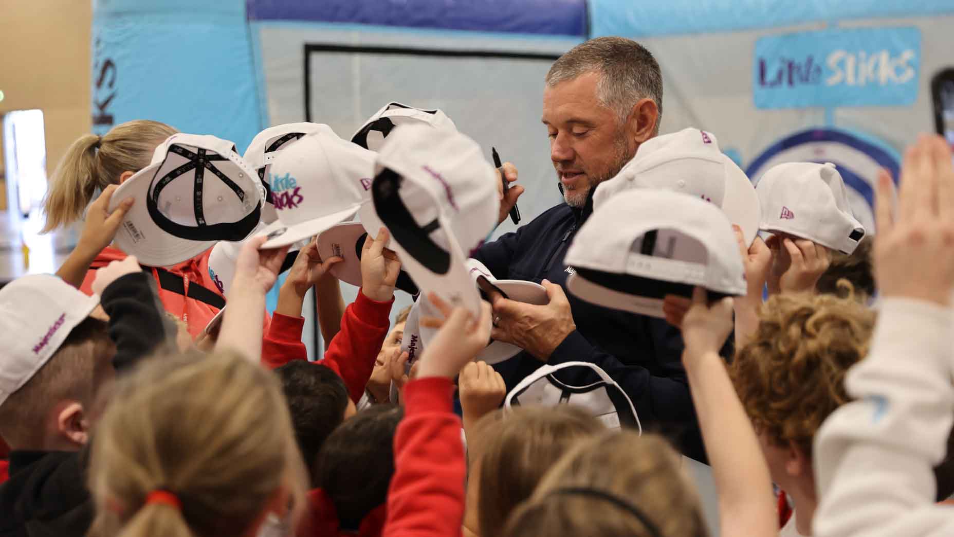 Lee Westwood signs hats for Little Sticks participants.