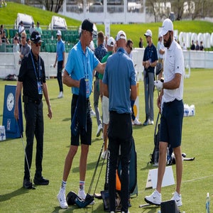 Scottie Scheffler on the range testing drivers with caddie Ted Scott, coach Randy Smith and TaylorMade's Adrian Reitveld.