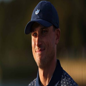 ludvig aberg smiles at the players championship in a navy hat and navy hsirt