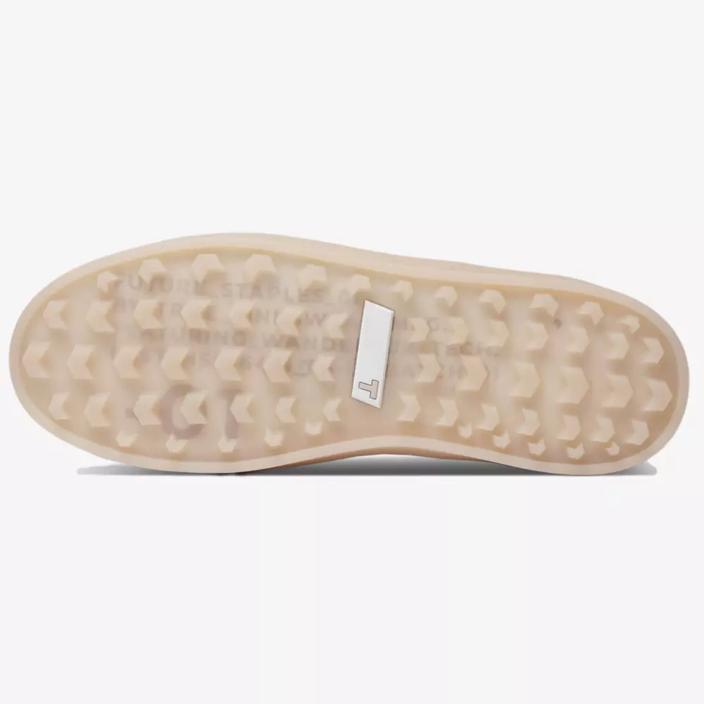 The image shows the bottom view of a shoe sole from one of the best women's golf shoes 2026, featuring a translucent, textured, and wavy tread pattern with a small rectangular white label near the center.