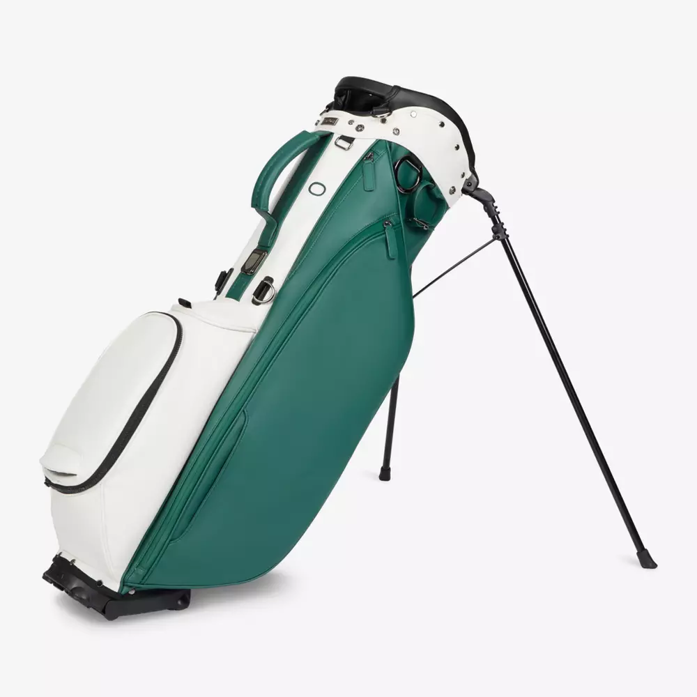 A green and white golf bag with multiple compartments stands upright on extendable black legs, offering stability&mdash;an ideal choice for those seeking the best golf bags 2026 has to offer.