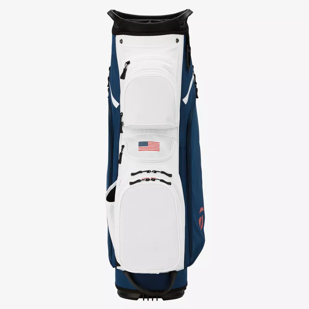A white and blue golf bag with an American flag patch on the front pocket, shown standing upright against a plain white background&mdash;an ideal pick for those seeking the best golf bags 2026 has to offer.