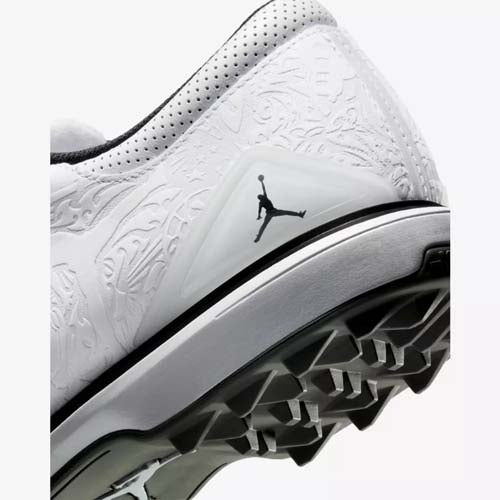Close-up of the heel of one of the best Jordan golf shoes—white athletic design with embossed patterns, a black Jumpman logo, and spiked outsole—showcasing top performance style for sports or golf.