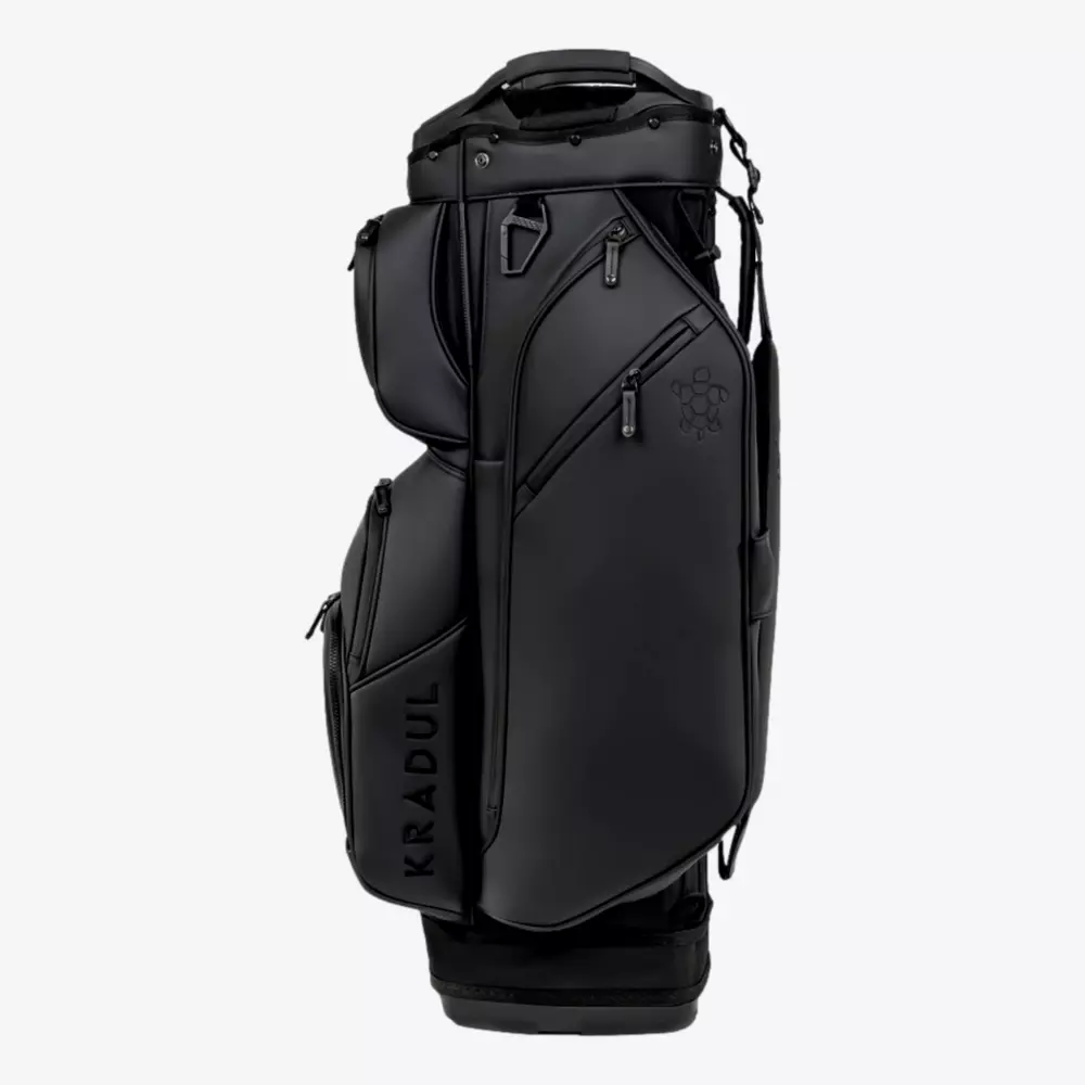 A sleek, black KRADUL golf bag&mdash;one of the best golf bags 2026&mdash;with multiple zippered compartments, a top carry handle, and a subtle logo on the upper pocket, shown standing upright against a plain white background.