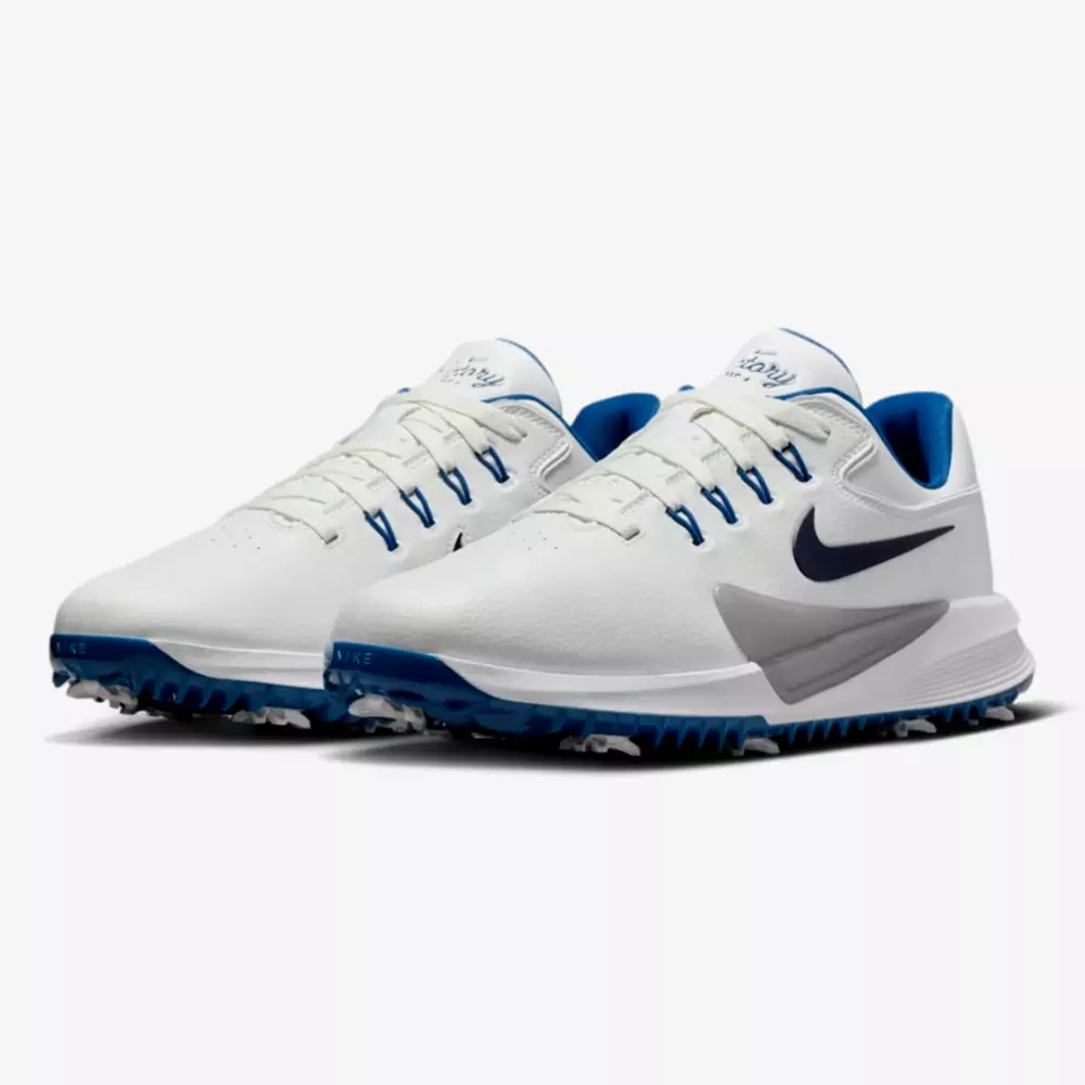 A pair of white Nike athletic shoes with blue accents, featuring a dark blue swoosh and spiked soles&mdash;perfect for sports or outdoor activities. These could be among the best golf shoes 2026 has to offer, displayed on a white background.