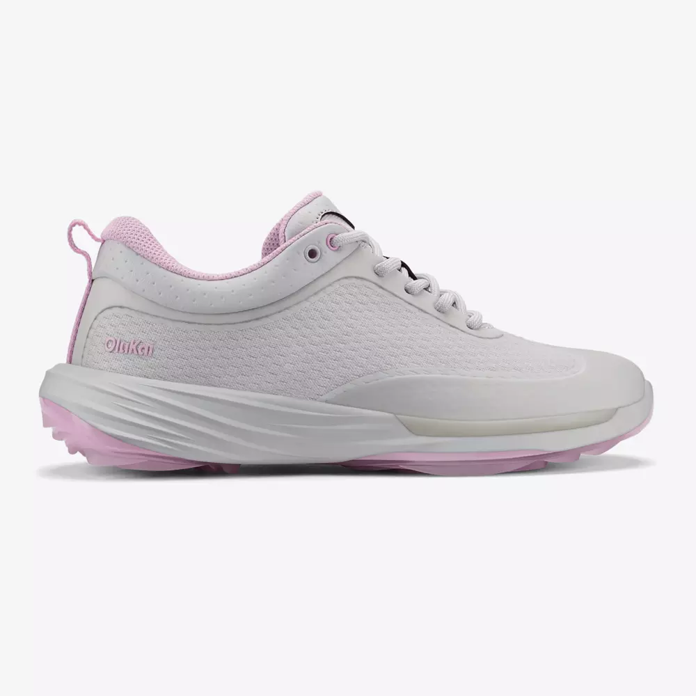 A white athletic sneaker with light pink accents on the sole, heel tab, and inner lining. The shoe&rsquo;s textured upper and lace-up design offer a sporty, low-profile silhouette&mdash;perfect style inspiration for the best golf shoes 2026.