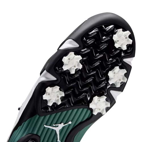 Close-up of the sole from one of the best Jordan golf shoes, featuring white cleats, a green textured section, and a white Jumpman logo. The outsole sports a black and white angular pattern for standout style and grip.