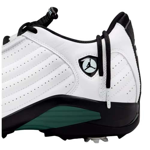 A close-up of one of the best Jordan golf shoes: a white athletic shoe with black laces, a black and green sole, and a small Jumpman logo in a shield on the side. The shoe features intricate stitching and perforated details.