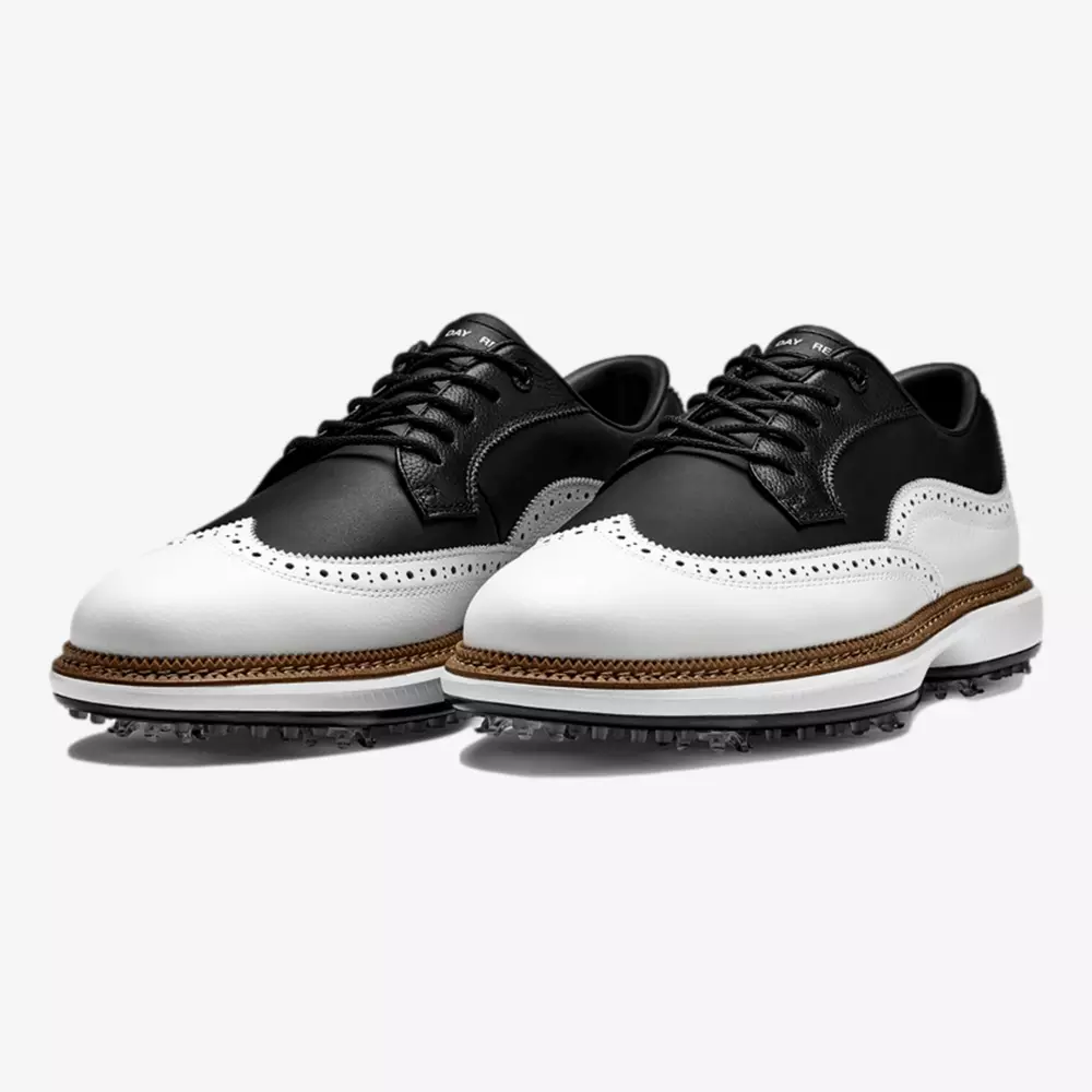 A pair of black and white leather wingtip golf shoes with brogue detailing, black laces, brown midsole accents, and textured rubber outsoles for grip&mdash;delivering classic style that rivals even the best Jordan golf shoes.