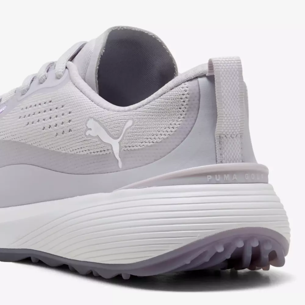 Close-up of the heel of a light gray Puma golf shoe, showing the Puma logo, textured upper material, ribbed white midsole, and part of the treaded sole&mdash;an ideal pick for those seeking the best women's golf shoes 2026.
