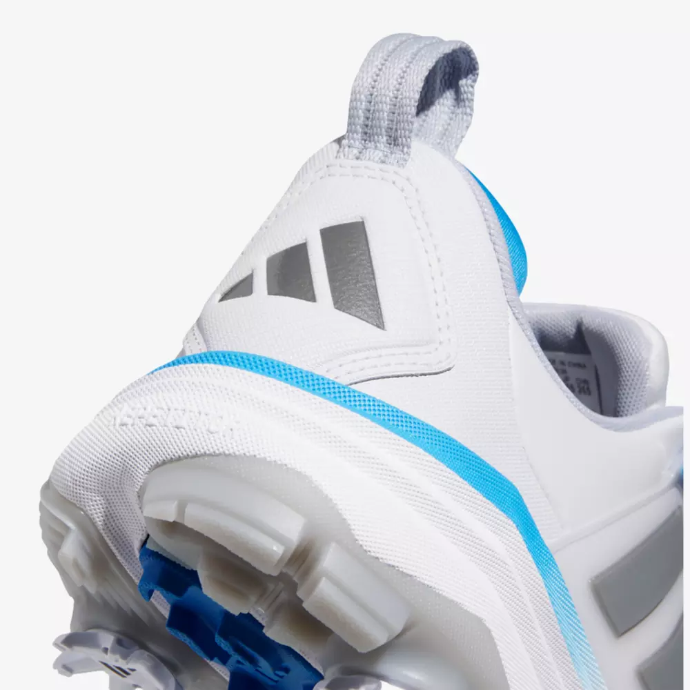 Close-up of the heel of a white athletic shoe with light blue accents, gray details, and a textured sole. A silver pull tab is visible at the back, along with a geometric logo inspired by the best Jordan golf shoes.