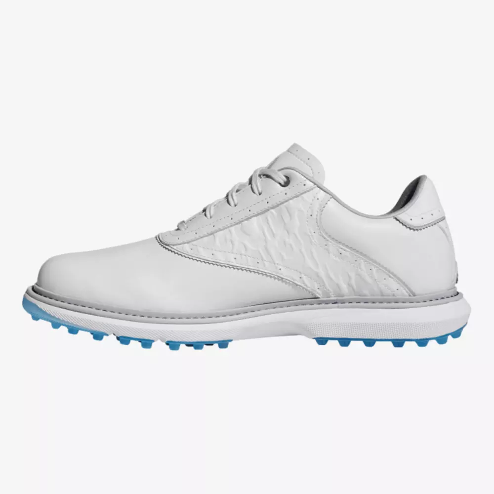 A white low-top golf shoe, inspired by the best Jordan golf shoes, features textured side paneling, white laces, and a light blue spiked sole, shown in profile against a plain white background.