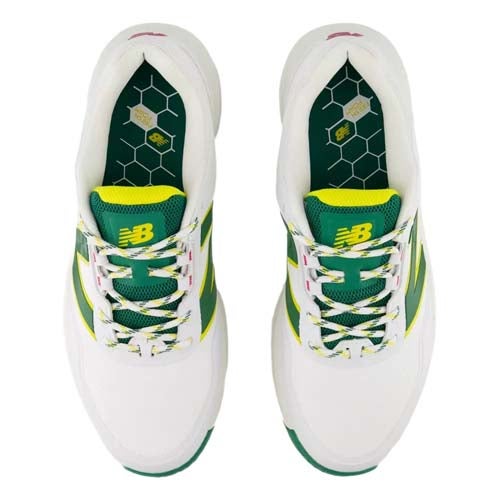 Top view of a pair of white athletic New Balance shoes with green and yellow accents, green mesh tongues, and hexagonal pattern insoles with a honeycomb design—channeling the best looks from The First Major.