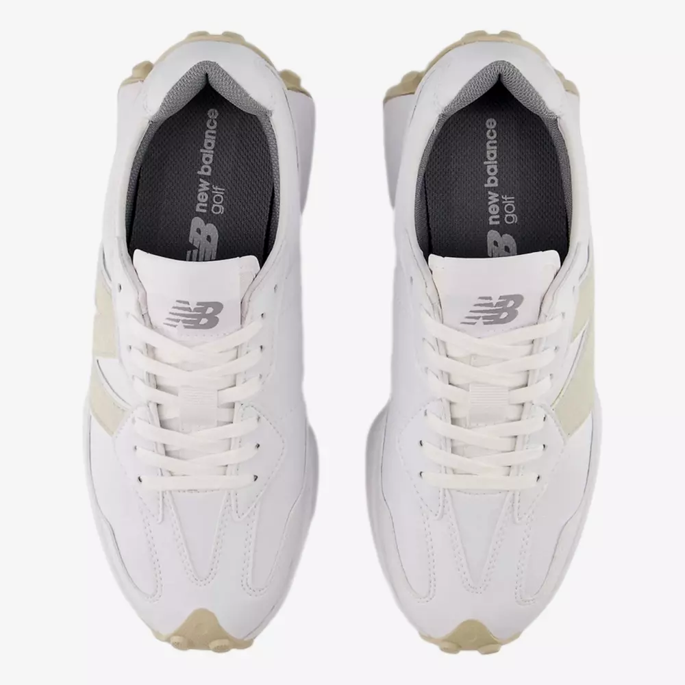 Top-down view of a pair of white New Balance golf shoes with beige accents and light tan soles. The insoles are dark gray and labeled new balance Golf in white text&mdash;an excellent pick for the best golf shoes 2026 lineup.