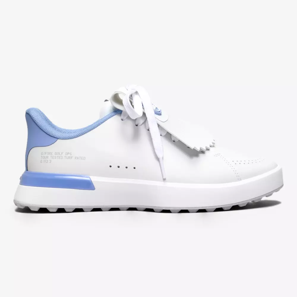 A white sneaker with a light blue heel, collar, and sole detail. Inspired by the best golf shoes 2026, it features white laces, a decorative fringe over the tongue, and a rugged outsole for a clean, modern look.