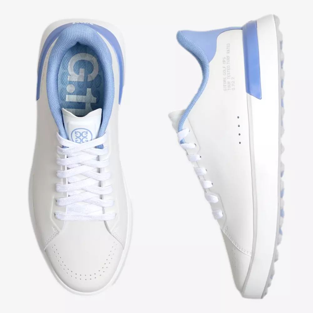 A pair of white sneakers with light blue accents on the heel, collar, and lining&mdash;designed for style and performance. Highlighted as some of the best golf shoes 2026, one shoe is shown from the top and the other from the side on a plain white background.