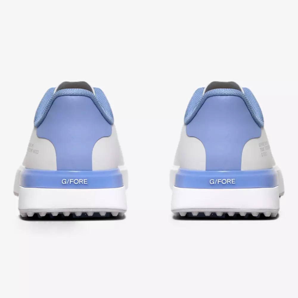 A pair of sneakers viewed from the back, featuring light blue, white, and gray colors with G/FORE printed on the heel. Designed for comfort with textured soles and a padded collar, they&rsquo;re contenders for the best golf shoes 2026.