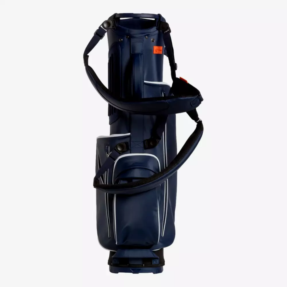 A navy blue golf bag with multiple zippered pockets, white trim accents, and a padded shoulder strap stands upright against a plain white background&mdash;an ideal choice for those seeking the best golf bags 2026.