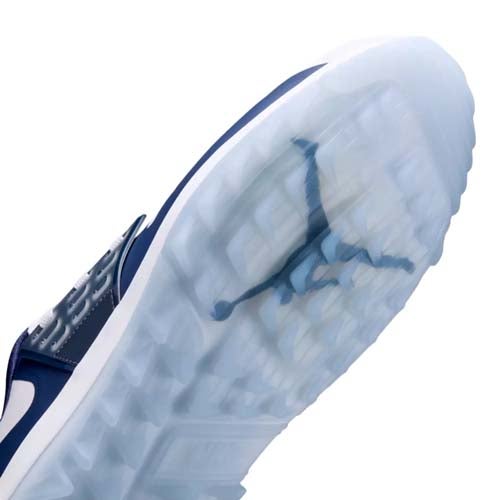 Close-up view of the translucent sole of a sneaker, featuring the Jumpman logo seen through the icy, textured rubber outsole—showcasing why this model ranks among the best Jordan golf shoes. The shoe is primarily navy and white.