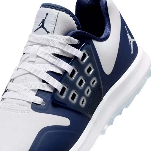 Close-up of a white and navy blue athletic sneaker featuring the Jumpman logo, white laces, and a modern, ventilated side panel design—perfect for those seeking the best Jordan golf shoes style and performance.