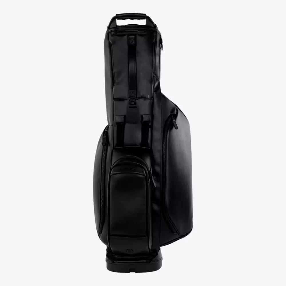 A sleek, black, modern golf bag&mdash;one of the best golf bags 2026 has to offer&mdash;with multiple zippered compartments and a sturdy handle, standing upright on a plain white background.