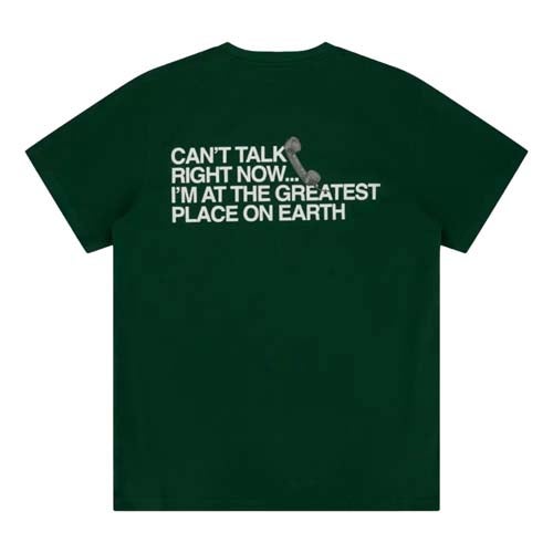 Dark green t-shirt with white text that reads, CANT TALK RIGHT NOW... IM AT THE GREATEST PLACE ON EARTH, featuring a small illustrated phone off the hook—one of the best looks from The First Major.