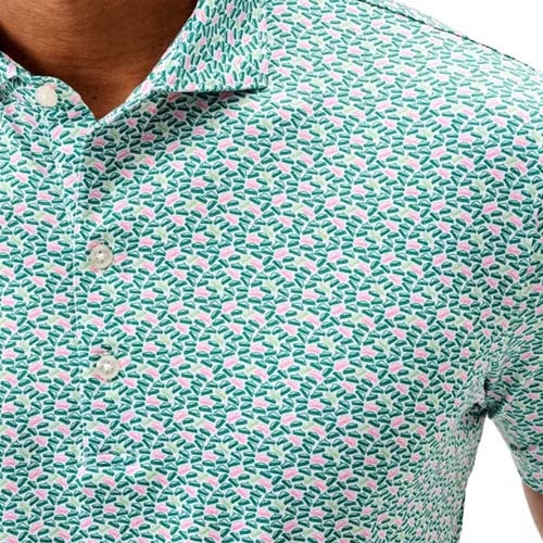 A close-up of a person wearing a light blue collared shirt with a small, colorful floral pattern in pink and green—one of the best looks from The First Major. The shirt features crisp white buttons down the front.