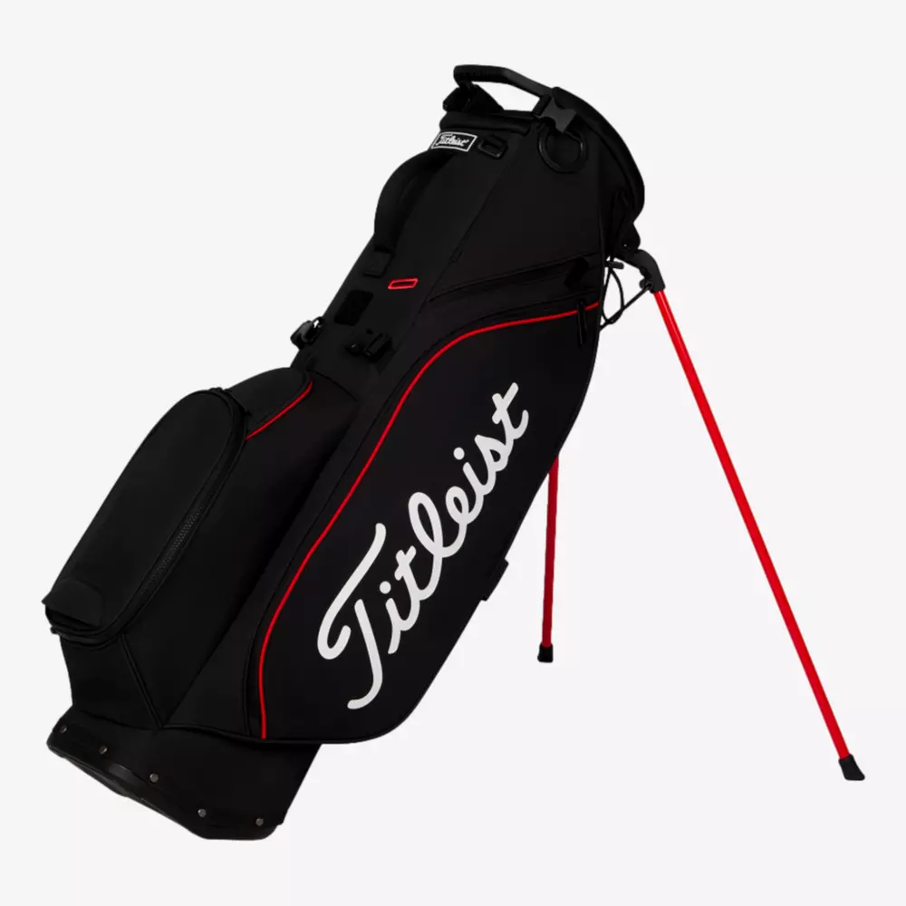 A black Titleist golf stand bag with red accents, side pocket, and two red legs extended for support is displayed against a plain white background&mdash;an ideal pick among the best golf bags 2026.