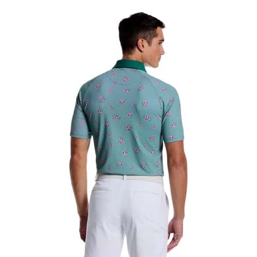A man facing away, wearing a teal polo shirt with a small pink and white pattern and a green collar, paired with white pants—one of the best looks from The First Major.