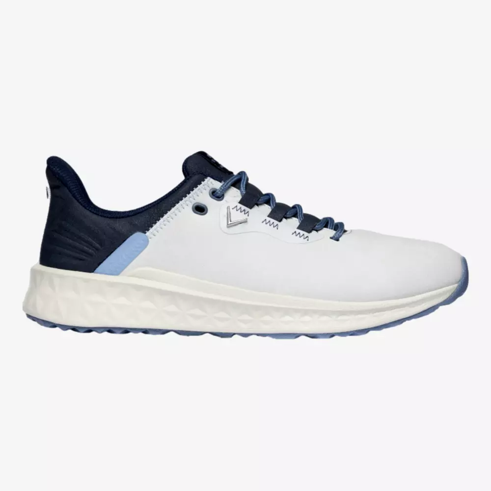 A white athletic sneaker with a thick, textured white sole, navy blue laces, blue heel detail, and a navy collar&mdash;styled in a side profile&mdash;makes a bold contender for the best golf shoes 2026 on a plain background.
