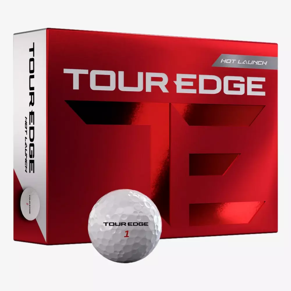 A red and silver box labeled TOUR EDGE HOT LAUNCH sits next to a white golf ball marked TOUR EDGE 1, shown against a plain white background&mdash;the perfect setup to pair with the best golf shoes 2026 for your next round.