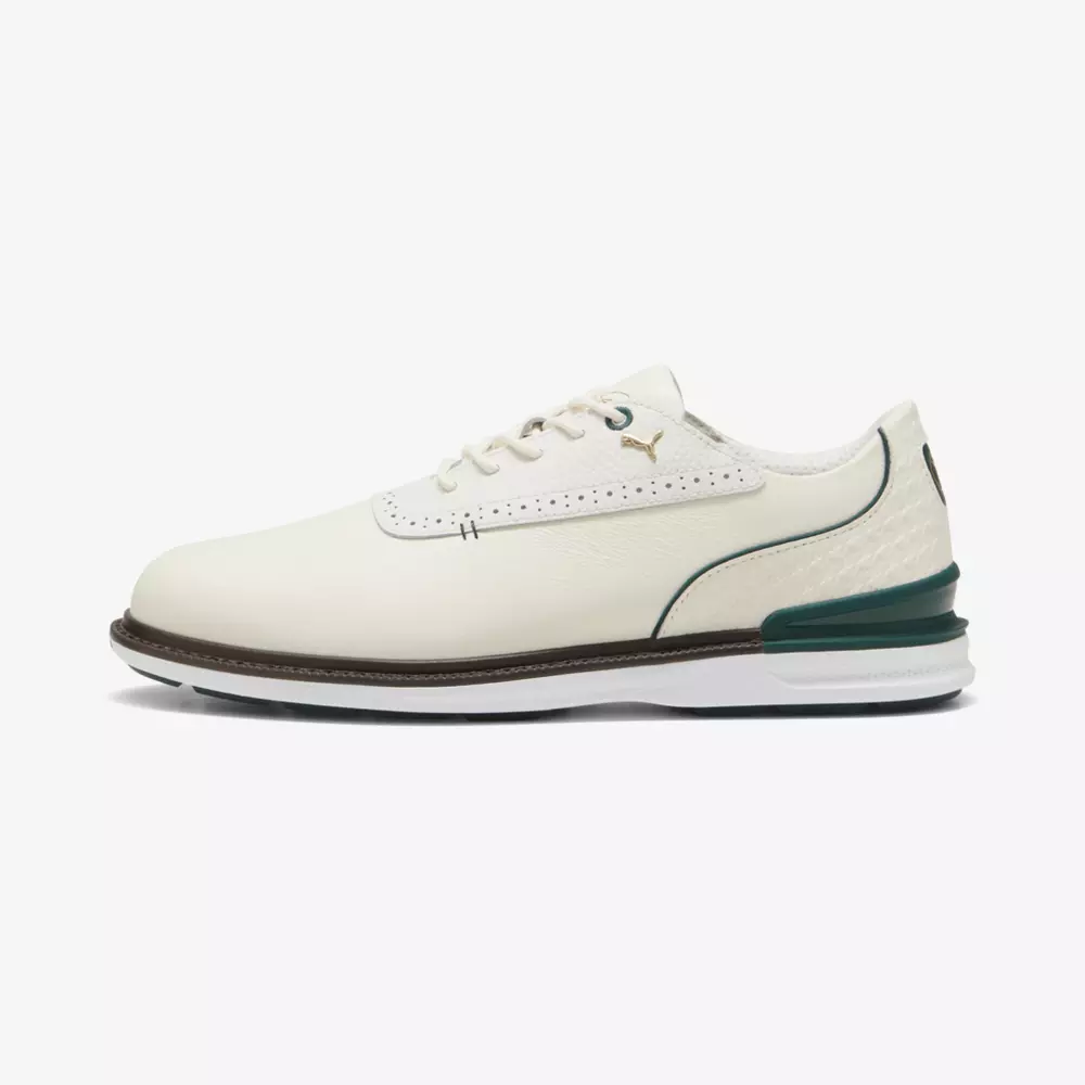 A white leather golf shoe with a brown sole, green accents on the heel and collar, white laces, and a small gold Puma logo on the side&mdash;perfect for those seeking style and comfort like the best Jordan golf shoes.