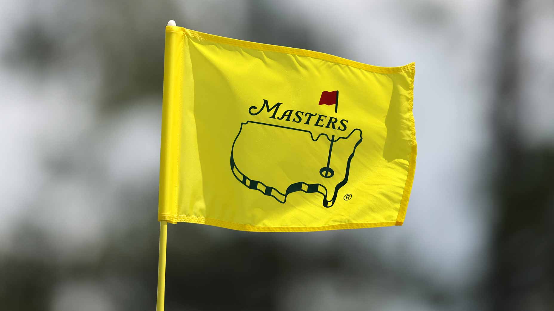 2026 Masters flag waving against a blurred outdoor background at Augusta National.