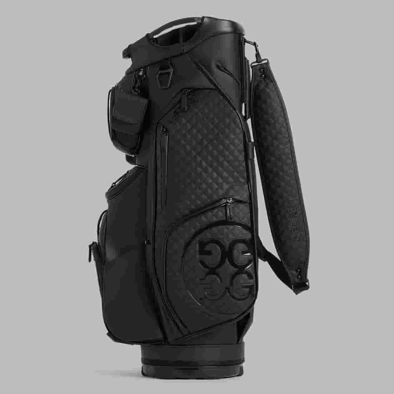 A black golf bag with a quilted pattern, multiple zippered pockets, a padded shoulder strap, and GG logo detailing—an elegant choice for those seeking the best golf bags 2026—displayed against a plain grey background.
