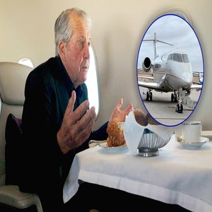 An older man, Gary Player, sits at a table with food on a private jet, gesturing with his hands. An inset shows a close-up of the jet he flew on the runway&mdash;perhaps reminiscing about the Masters.