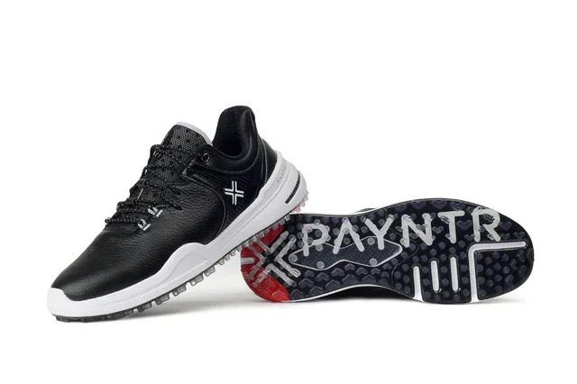 A pair of black and white athletic shoes, with one shoe upright and the other lying on its side, showcasing the sole with the word PAYNTR and a cross design&mdash;perfect contenders for the best golf shoes 2026.