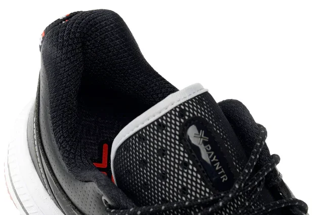 Close-up view of a black athletic shoe with textured mesh fabric, white sole, and laces. The tongue features a small black label with DAYNTR branding in white letters, offering a style that rivals the best golf shoes 2026 has to offer.
