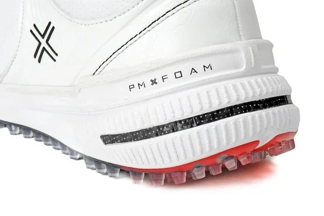 Close-up of the heel of a white athletic shoe with PMX FOAM printed on the side, black detailing, and a red and translucent spiked sole designed for traction&mdash;an advanced design seen in the best golf shoes 2026.