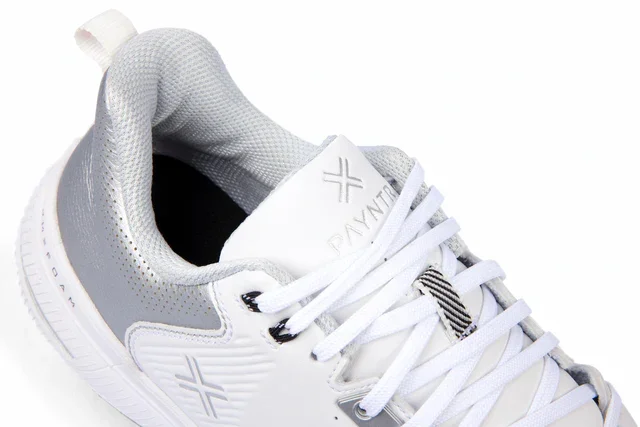 A close-up of a white athletic sneaker with gray and silver accents, white laces, and subtle branding details on the tongue and side&mdash;designed for comfort, it could be among the best golf shoes 2026 has to offer.