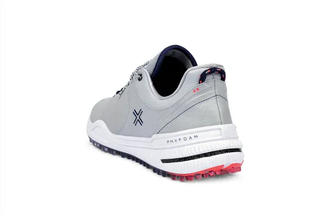 A gray athletic shoe with a white midsole, black and pink outsole, and navy blue accents is shown angled from the back on a white background. Perfect for performance seekers, this design could inspire the best golf shoes 2026 collections.