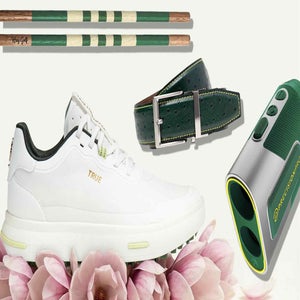 A white sneaker, a green leather belt, a golf rangefinder, and two green-and-tan tees are arranged among pink lotus flowers&mdash;an elegant nod to the Masters.