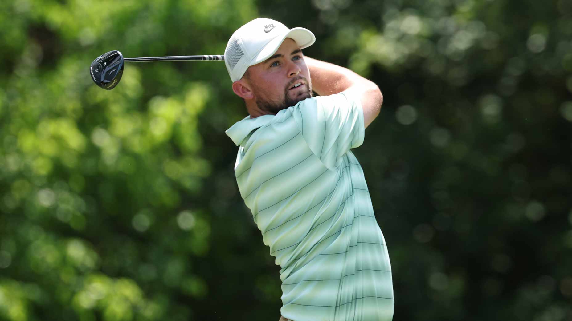 2026 Cadillac Championship Thursday tee times: Alex Fitzpatrick wearing a light green striped shirt and white cap follows through on a golf swing.