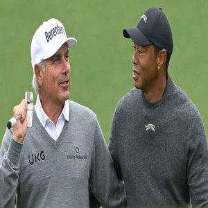 Tiger Woods and Fred Couples hug while walking together on the ninth fairway prior to Masters Tournament at Augusta National Golf Club on April 9, 2024