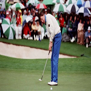 A golfer in blue pants and a white sweater putts on the green at Augusta National, as a crowd of spectators with umbrellas watches from near the sand bunker&mdash;capturing one of the scariest shots faced by any Masters winner.