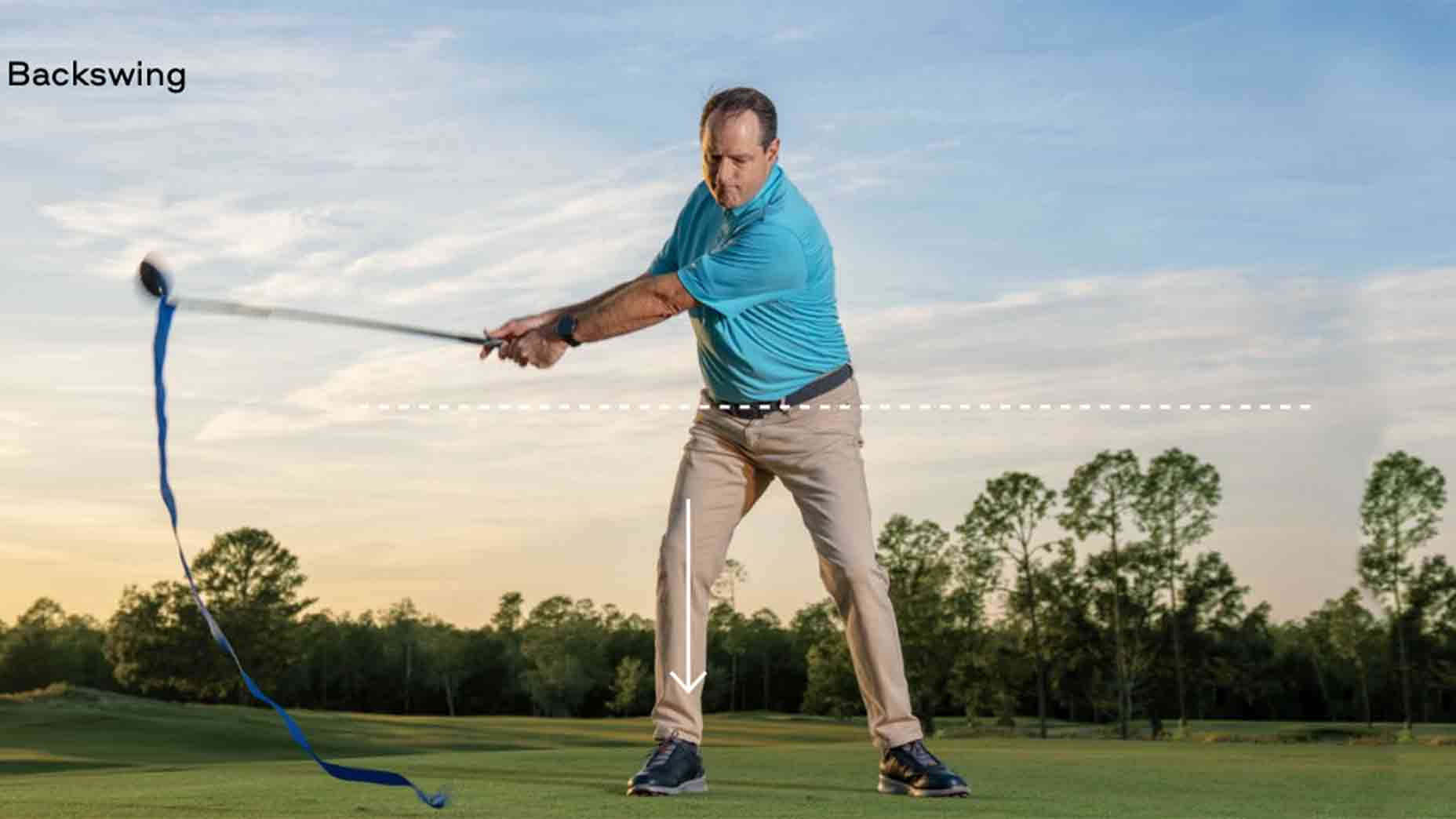 A pressure player in a blue shirt and beige pants demonstrates a backswing on a grassy course, with a curved blue line tracing the club's motion—perfect technique to hit more bombs. Trees and a blue sky form the scenic background.