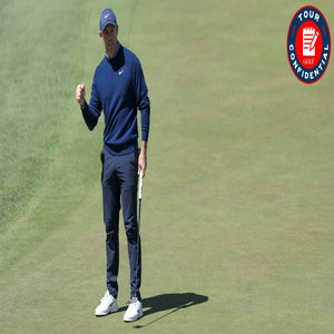 A golfer wearing a navy sweater, dark pants, and a cap celebrates with a fist pump while standing on a golf green, holding a putter. A red Tour Confidential logo appears in the top right corner.
