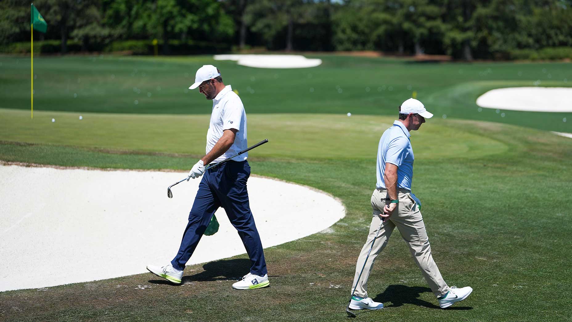 Scottie Scheffler and Rory McIlroy pass each other in the practice area prior to their rounds beginning on Sunday at the Masters.