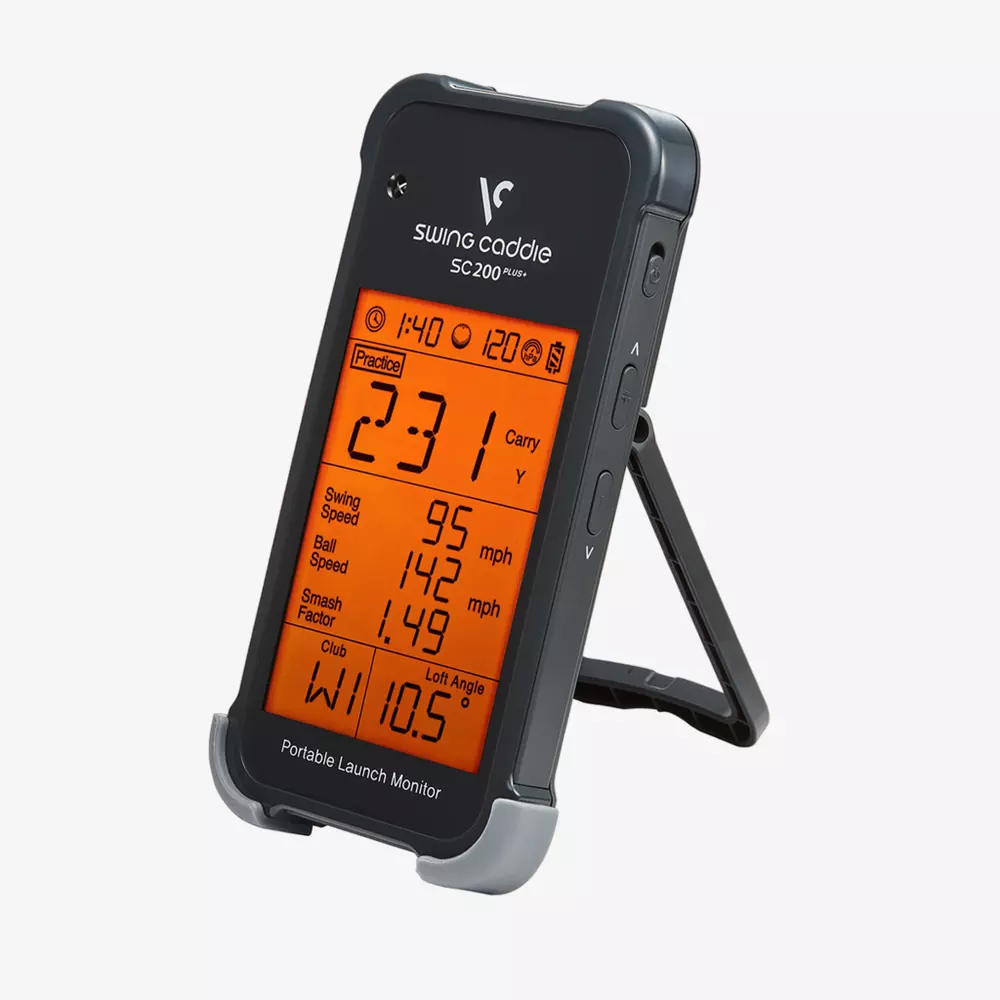 A black Swing Caddie SC200 Plus portable launch monitor with an orange display showing golf stats like carry distance and swing speed, standing on its built-in stand&mdash;one of the best golf deals for $100 or less.