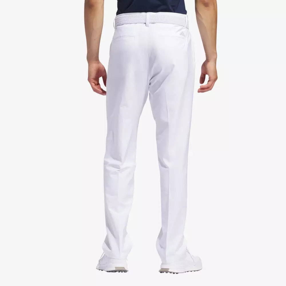 A person is shown from the back, wearing white dress pants, a dark shirt, a white belt, and white shoes, standing against a plain background—evoking the sleek style seen with the best golf travel bags.